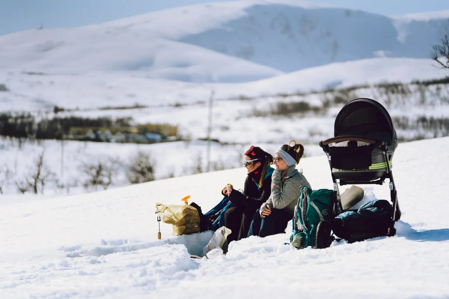 To personer og en barnevogn i snøen