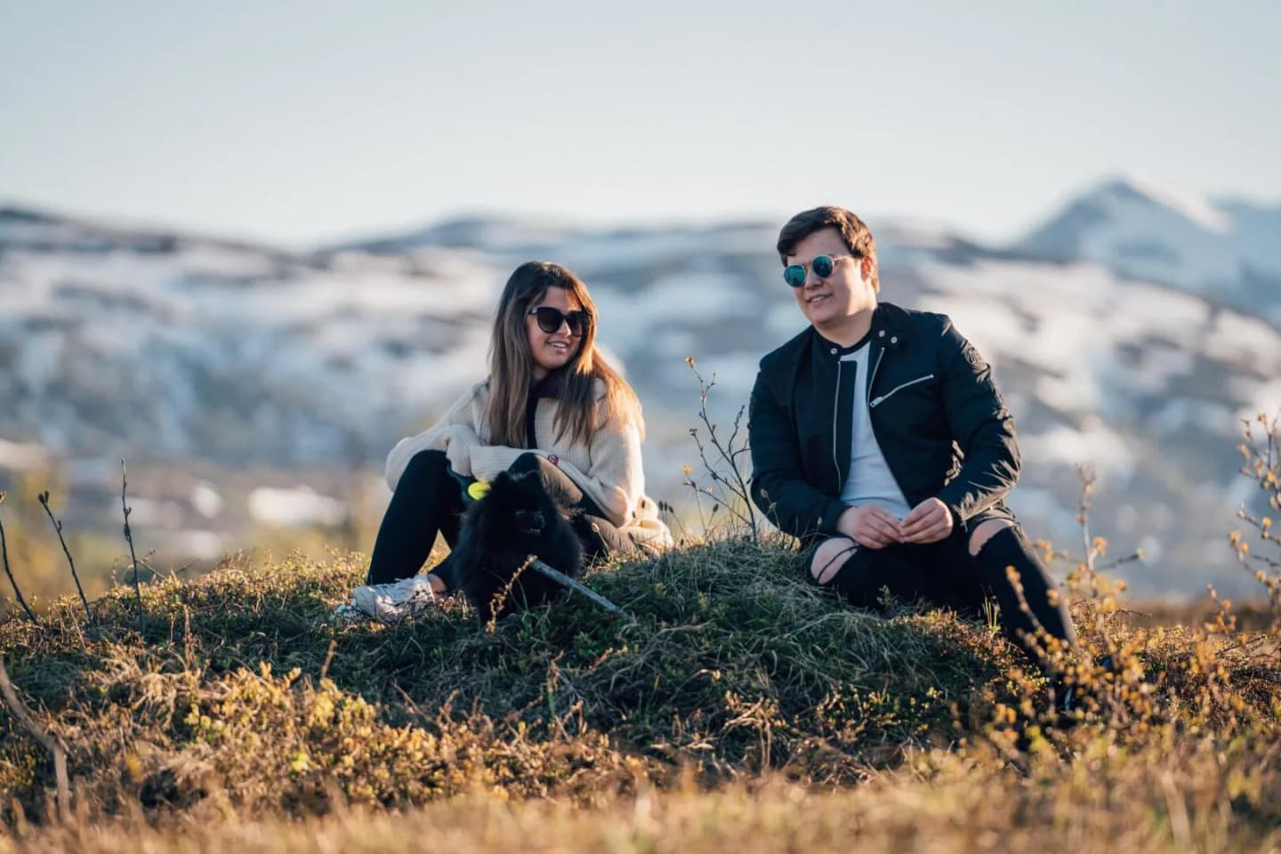 To personer og en hund i fjellet